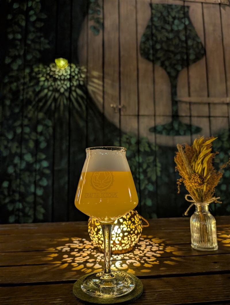 Volles Bierglas im Schein einer Laterne vor dem Hopfen-Wandbild